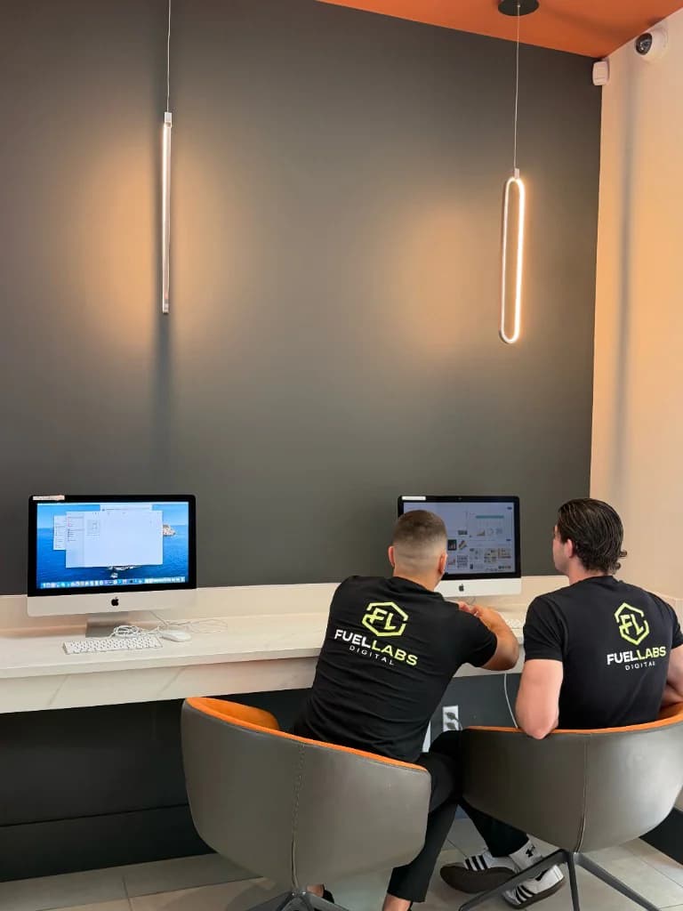 FuelLabs founders smiling in front of the workstations