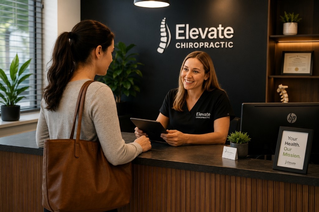 Patient checking in with a receptionist at a modern chiropractic clinic