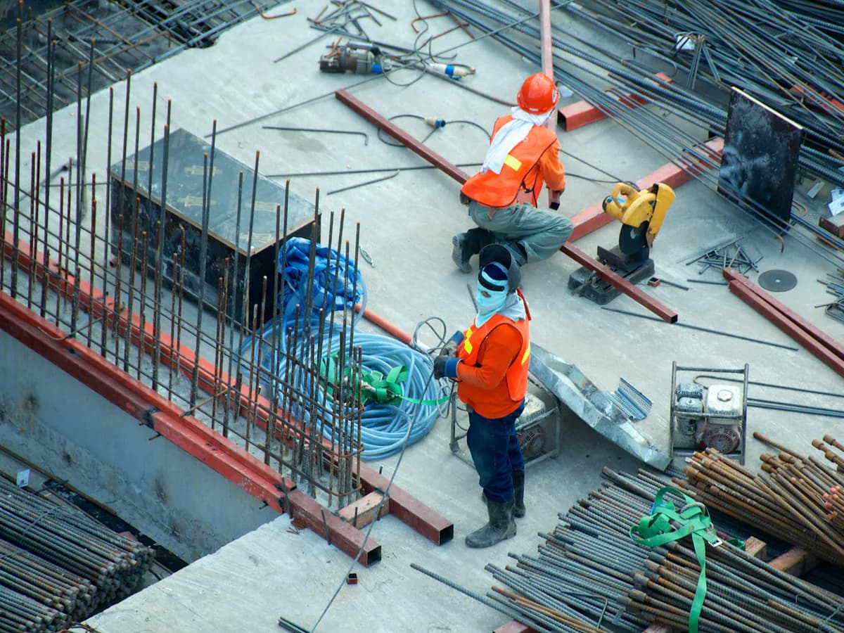 Construction crew placing steel and conduit on an active concrete deck
