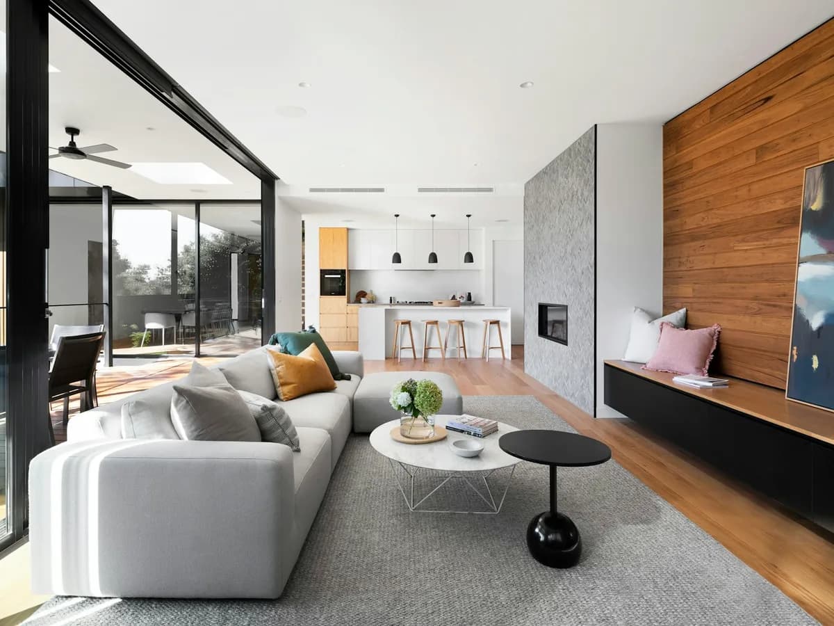 Open living room with wood-slat feature wall, stone fireplace surround, and hardwood flooring