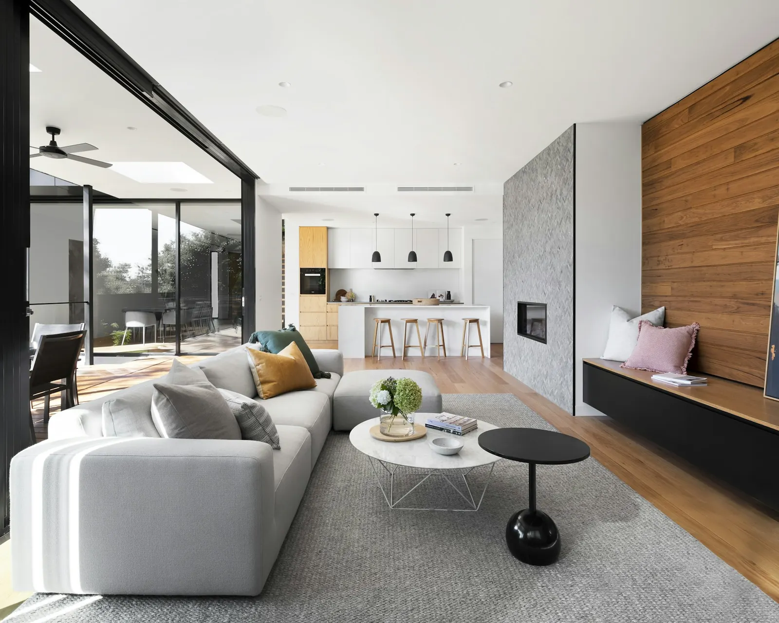 Completed modern living room with sectional sofa, fireplace wall, and glass doors to patio